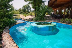 a swimming pool in a backyard with a blue pool at Guest House Mala Prica in Živinice