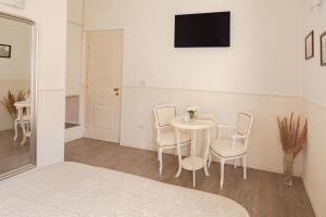 a white room with a table and chairs and a tv at Dante's in Vaticano in Rome