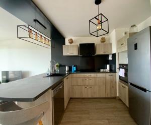 a kitchen with wooden cabinets and a white refrigerator at Le Strada- Terrace and central position! in Montpellier