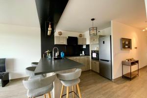 a kitchen with a table and some chairs in a room at Le Strada- Terrace and central position! in Montpellier
