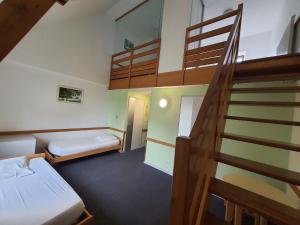 a small room with two beds and a staircase at Gîte de Manehouarn in Plouay