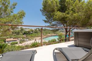 een balkon met stoelen en uitzicht op het water bij Cala Mendia Beach House 1 by Slow Villas in Cala Romantica