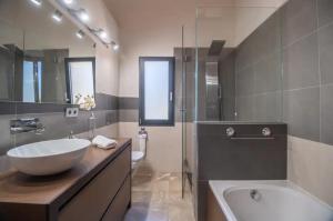 a bathroom with a large sink and a tub and a tubermott at S'alzinar Villa in Sa Pobla +17 photos