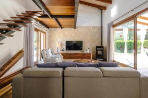 uma sala de estar com um sofá e uma televisão em S'alzinar Villa em Sa Pobla