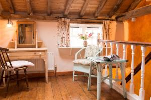 a room with a table and a chair and a window at The Bakery a honeymooners favourite cosy stylish with lovely walks and pubs 