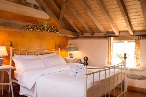 a bedroom with a white bed with a wooden ceiling at The Bakery a honeymooners favourite cosy stylish with lovely walks and pubs 