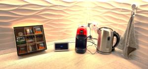 eine Arbeitsplatte mit einem Telefon neben einem Toaster und einer Thermoskanne in der Unterkunft Villa Costanza in Bari