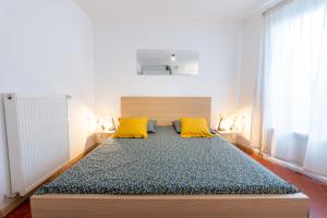 a large bed with two yellow pillows in a room at Superbe studio cosy et calme in Digne-les-Bains