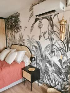 a bedroom with a bed with a tropical wallpaper at Le Port Camargue- 2 bedrooms and air-conditioned ! in Le Grau-du-Roi