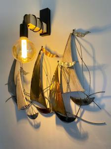 a chandelier with a model of a boat on a wall at Le Port Camargue- 2 bedrooms and air-conditioned ! in Le Grau-du-Roi