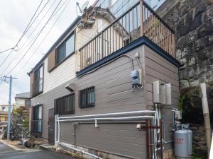 un edificio con una escalera en el lateral en 一棟貸しの民泊いとんちゅ, en Nagasaki