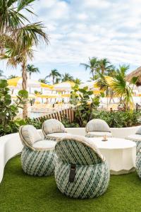 un grupo de sillas y una mesa en el césped en Newport Beachside Hotel & Resort en Miami Beach
