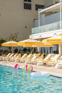 uma piscina com cadeiras e guarda-sóis e uma piscina em Newport Beachside Hotel & Resort em Miami Beach