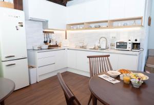 a kitchen with a table and a kitchen with white cabinets at Hanok Stay SungHyeDang in Gyeongju