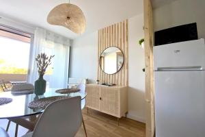 a kitchen and dining room with a table and a mirror at Lensoleillée - Proche port et climatisé ! in Mauguio