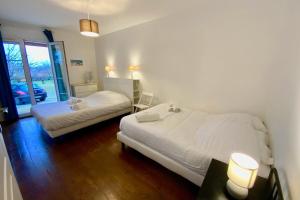 Un dormitorio con 2 camas y una mesa con lámparas. en La Bucolique-Villa in the heart of greenery! en Saint-Jean-de-Védas