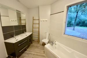 baño con bañera, lavabo y ventana en La Bucolique-Villa in the heart of greenery! en Saint-Jean-de-Védas