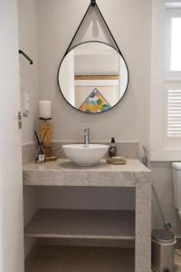 a bathroom with a sink and a mirror at Casa da Praça 43 in Tiradentes +45 photos