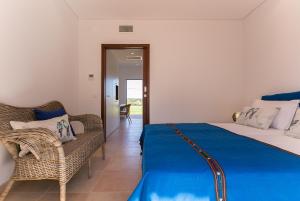a bedroom with a bed and a couch and a chair at Casas Do Rio Sado - Sado River Country Retreat in Santa Margarida do Sado +45 photos