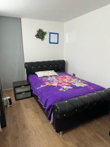 a bed with a purple comforter in a bedroom at Captivating 1-Bed Apartment in London in London