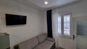 Il comprend un salon doté d'un canapé et d'une télévision à écran plat. dans l'établissement Apartments Villa Flamingo, à Makarska