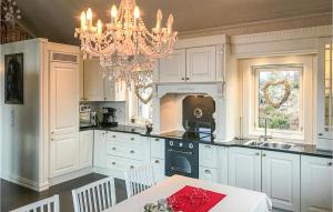 uma cozinha com armários brancos e um lustre em Nice Home In Stadlandet With House A Mountain View em Hundsnes