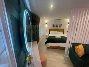 a bedroom with a bed with a neon sign on the wall at Swish Studio in Colchester