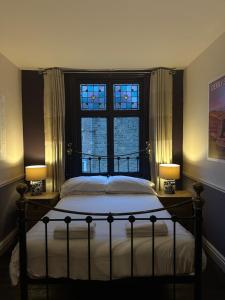 a bedroom with a bed with two lamps and a window at The Old Poets Corner in Chesterfield