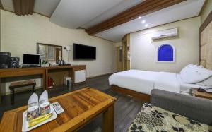 a large hotel room with a bed and a desk at Cheongju Ochang memory stay in Cheongju