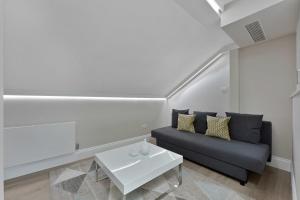 - un salon avec un canapé et une table dans l'établissement Cleveland Residences Russell Square, à Londres