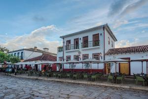 a building with tables and chairs on a street at Casa da Praça 43 in Tiradentes
