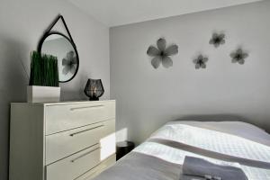 una camera da letto con cassettiera e specchio sul muro di Le fonctionnel - Grande terrasse en plein centre ! a Castelnau-le-Lez