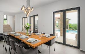 a dining room with a long wooden table and chairs at Gorgeous Home In Buje With Wifi in Veli Vrh