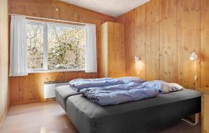 een slaapkamer met een bed in een kamer met een raam bij Gorgeous Home In Fars With Sauna in Farsø