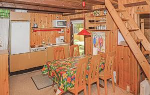 a kitchen and dining room with a table in a cabin at Two-Bedroom Holiday Home In Hemmet in Hemmet