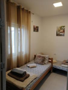 a small bedroom with a bed with a window at Apartments Željka-Dobrota in Kotor