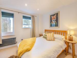 a bedroom with a bed and a dog painting on the wall at Wye View Cottage in Ross on Wye