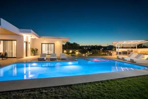 a villa with a swimming pool at night at Ocean Pearl Sea View in Faliraki