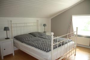 1 dormitorio con cama blanca y ventana en "Weißes Haus" 9123II - Fehmarn, en Fehmarn