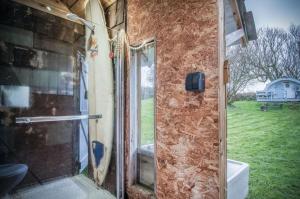 a glass shower door in a room with a window at The Pod - 1 Bedroom - Freshwest Beach Retreat in Pembroke