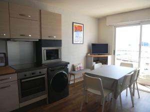 a kitchen and dining room with a table and a television at Appartement Étel, 3 pièces, 5 personnes - FR-1-479-71 in Étel