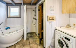 a bathroom with a tub and a washing machine at 3 Bedroom Gorgeous Apartment In Rechlin in Rechlin +6 photos