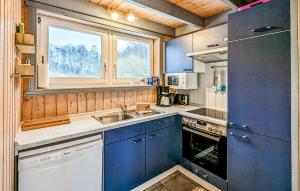 a kitchen with blue cabinets and a sink and a window at 3 Bedroom Gorgeous Apartment In Rechlin in Rechlin