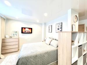 a bedroom with a bed and a tv on the wall at Modern Charming Studio Narva Center in Narva