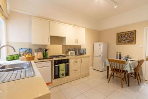 eine Küche mit weißen Geräten und einem Tisch mit einem Tableablish in der Unterkunft The Old Bakery in Southwold
