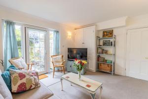 ein Wohnzimmer mit einer Vase mit Blumen auf einem Tisch in der Unterkunft The Old Bakery in Southwold
