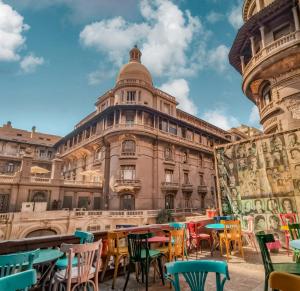 カイロにあるNew Cairo Heartの目の前にカラフルなテーブルと椅子が置かれた建物