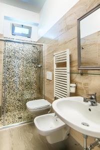 y baño con lavabo, aseo y ducha. en Albergo Villa Lucia, en Bellaria-Igea Marina