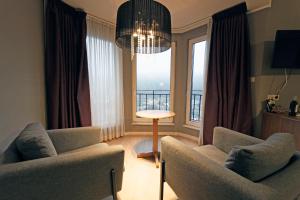 a living room with two chairs and a large window at Hotel Panorama in Bouillon