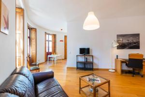 een woonkamer met een leren bank en een tafel bij Casa Trindade Apartments in Porto